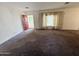 Spacious living room with vintage carpet, a red front door and natural light from the window at 3215 W Orangewood Ave, Phoenix, AZ 85051
