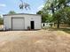 View of the building exterior with rolling door and a separate outbuilding with a chair nearby at 3215 W Orangewood Ave, Phoenix, AZ 85051