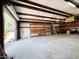 Outbuilding interior with concrete floor, shelves, and large roll up door at 3215 W Orangewood Ave, Phoenix, AZ 85051