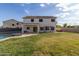 The backyard has a sparkling pool, green grass, a large patio, and solar panels on the home at 3491 N 301St Dr, Buckeye, AZ 85396