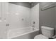 Clean bathroom with a white tiled bathtub, white toilet, and modern fixtures at 3491 N 301St Dr, Buckeye, AZ 85396
