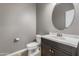 Stylish half-bathroom with modern vanity, fixtures, and a decorative round mirror at 3491 N 301St Dr, Buckeye, AZ 85396
