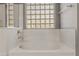 Close-up of a clean and bright bathtub with a glass block window adding natural light at 3491 N 301St Dr, Buckeye, AZ 85396