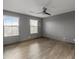Spacious bedroom features tile flooring, two windows, ceiling fan, and neutral color palette at 3491 N 301St Dr, Buckeye, AZ 85396