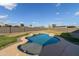 Beautiful backyard featuring a sparkling in-ground pool and a well-maintained lawn perfect for outdoor relaxation at 3491 N 301St Dr, Buckeye, AZ 85396