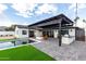 Serene backyard with a pool, fire pit, outdoor kitchen, and lush artificial turf at 3502 N Rose Circle Dr, Scottsdale, AZ 85251
