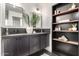 Contemporary bathroom boasting double sinks, dark cabinetry, and open shelving for storage at 3502 N Rose Circle Dr, Scottsdale, AZ 85251
