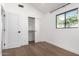 Bright bedroom with a window view, featuring hardwood floors and closet with sliding doors at 3502 N Rose Circle Dr, Scottsdale, AZ 85251