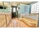Relaxing bathroom with soaking tub, tiled floors and walls, and a stylish decorative window at 36721 N 17Th Ave, Phoenix, AZ 85086