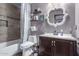 Bathroom featuring a shower-tub combination, dark vanity, and decorative shelves at 4243 E Jasper Dr, Gilbert, AZ 85296