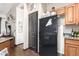 Cozy kitchen featuring dark wooden floors, a black fridge, and ample storage space in light wood cabinetry at 4243 E Jasper Dr, Gilbert, AZ 85296
