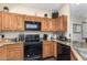Kitchen showcasing wood cabinets, black appliances including a microwave and oven range, and speckled countertops at 4243 E Jasper Dr, Gilbert, AZ 85296