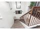 Carpeted staircase with white walls, metal handrails, a decorative chair on the landing, illuminated by a window above at 4243 E Jasper Dr, Gilbert, AZ 85296