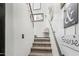 Carpeted staircase with white walls, and a decorative chair on the landing, illuminated by a window above at 4243 E Jasper Dr, Gilbert, AZ 85296