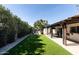 Expansive backyard with well-manicured artificial grass and a covered patio with outdoor seating at 4317 E Ludlow Dr, Phoenix, AZ 85032