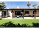 Relaxing backyard featuring artificial grass, a covered patio, and outdoor dining furniture at 4317 E Ludlow Dr, Phoenix, AZ 85032