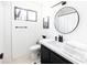 Well-lit bathroom with a sleek vanity, modern fixtures, and a decorative round mirror above the sink at 4317 E Ludlow Dr, Phoenix, AZ 85032