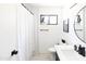 Bright bathroom featuring tile flooring, white walls, modern fixtures, and a window for natural light at 4317 E Ludlow Dr, Phoenix, AZ 85032