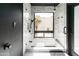 Modern bathroom with marble tile, rainfall shower head, soaking tub and large window to private yard at 4317 E Ludlow Dr, Phoenix, AZ 85032