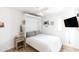 Bright bedroom with wood floors, ceiling fan, pull down bed, mounted television, and cactus decor at 4317 E Ludlow Dr, Phoenix, AZ 85032
