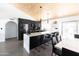 Modern kitchen featuring quartz counters, stainless steel appliances, black cabinets, and concrete floors at 4317 E Ludlow Dr, Phoenix, AZ 85032