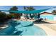 Outdoor swimming pool with clear blue water, shaded lounging areas, and mature landscaping at 4317 E Ludlow Dr, Phoenix, AZ 85032