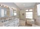 Bright bathroom featuring double sinks, a walk-in shower with glass enclosure, and tile accents at 4609 E Monte Cristo Ave, Phoenix, AZ 85032