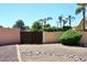 Gated side yard area with gravel, decorative rocks, mature landscaping, and a privacy wall at 4609 E Monte Cristo Ave, Phoenix, AZ 85032
