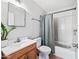 This bathroom features a vanity sink with wood cabinets, a toilet, and a shower with a curtain at 4828 N 71St Ave, Phoenix, AZ 85033