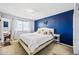 Bedroom with blue accent wall, light carpet, and ample natural light at 4828 N 71St Ave, Phoenix, AZ 85033