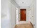 View of a hallway with tile flooring leading to a wooden door at 4828 N 71St Ave, Phoenix, AZ 85033