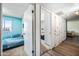 Hallway view of a bedroom with blue paneled walls and view to another room with built in storage at 4828 N 71St Ave, Phoenix, AZ 85033