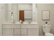 Bright bathroom featuring a double vanity with modern fixtures and a neutral color palette at 4987 S 233Rd Dr, Buckeye, AZ 85326