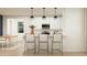 Open-concept kitchen featuring white cabinets, modern appliances, and bar seating at 4987 S 233Rd Dr, Buckeye, AZ 85326