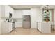 Well-lit kitchen with stainless steel appliances, sleek white cabinetry, and a breakfast bar at 4987 S 233Rd Dr, Buckeye, AZ 85326