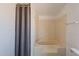 Close up of bathtub/shower with a beige shower curtain to the left at 54073 W Stallion Rd, Maricopa, AZ 85139
