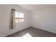 A bright bedroom with a window and grey wood-look flooring at 54073 W Stallion Rd, Maricopa, AZ 85139