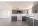 Bright kitchen with gray cabinets, stainless appliances, laminate counters, and new flooring at 54073 W Stallion Rd, Maricopa, AZ 85139