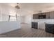 Open-concept kitchen features gray cabinets, laminate counters, and new flooring at 54073 W Stallion Rd, Maricopa, AZ 85139