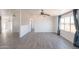 Living room featuring hardwood floors, a ceiling fan, large windows, and an open layout at 54073 W Stallion Rd, Maricopa, AZ 85139