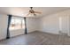 Living room featuring hardwood floors, ceiling fan, large windows, and neutral wall colors at 54073 W Stallion Rd, Maricopa, AZ 85139