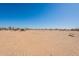 A wide open desert landscape with a clear blue sky overhead, offering a sense of vastness at 54073 W Stallion Rd, Maricopa, AZ 85139
