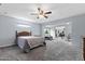 Spacious bedroom with neutral carpet and paint, featuring a ceiling fan and a view to a living room at 633 Leisure World --, Mesa, AZ 85206
