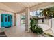 Inviting covered patio with a turquoise front door, tiled flooring, and lush landscaping offering a serene outdoor space at 633 Leisure World --, Mesa, AZ 85206