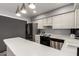 Kitchen features white cabinets, stainless steel appliances, and modern pendant lighting fixtures at 6348 N 7Th Ave # 6, Phoenix, AZ 85013