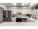 Updated kitchen features stainless steel appliances, white cabinets, and modern lighting fixtures at 6348 N 7Th Ave # 6, Phoenix, AZ 85013