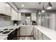Well-lit kitchen with white cabinets, countertops, stainless steel appliances and a view of the backyard at 6348 N 7Th Ave # 6, Phoenix, AZ 85013