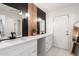 Modern bathroom featuring dual sinks, vanity, mirrors, stylish light fixtures, and a doorway at 6869 E Flossmoor Ave, Mesa, AZ 85208
