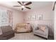 Charming bedroom showcasing a crib, chair, ceiling fan, and playful decor elements at 6869 E Flossmoor Ave, Mesa, AZ 85208