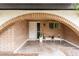 Cozy front porch with arched brick detailing and comfortable seating area, offering a welcoming entry way at 6869 E Flossmoor Ave, Mesa, AZ 85208